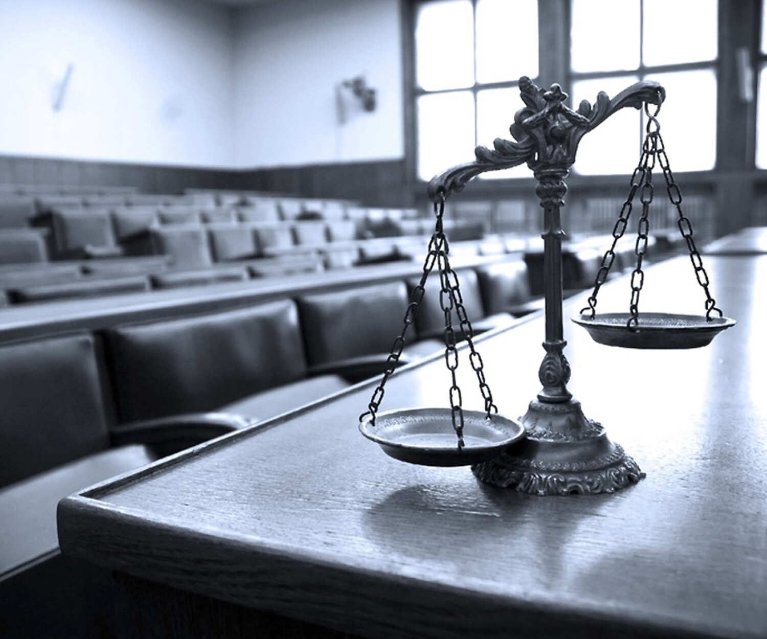 A scale on a table in front of a row of chairs, indicating a court room appearance