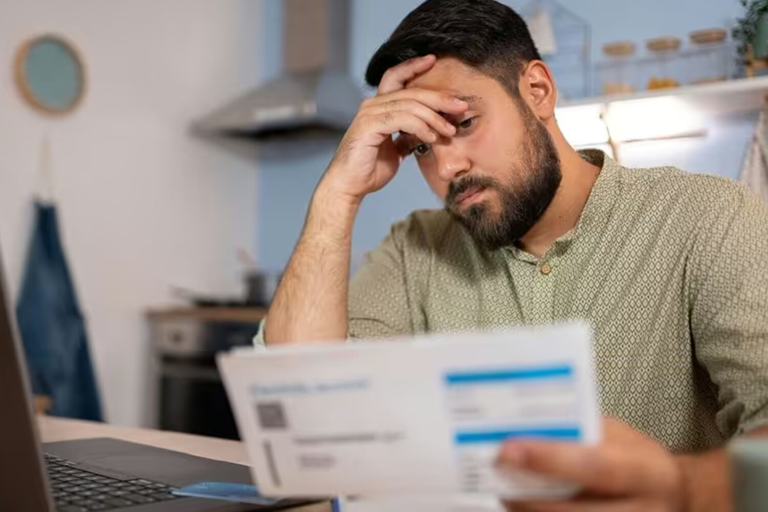 A man looking at a report with his hand on his face in frustration