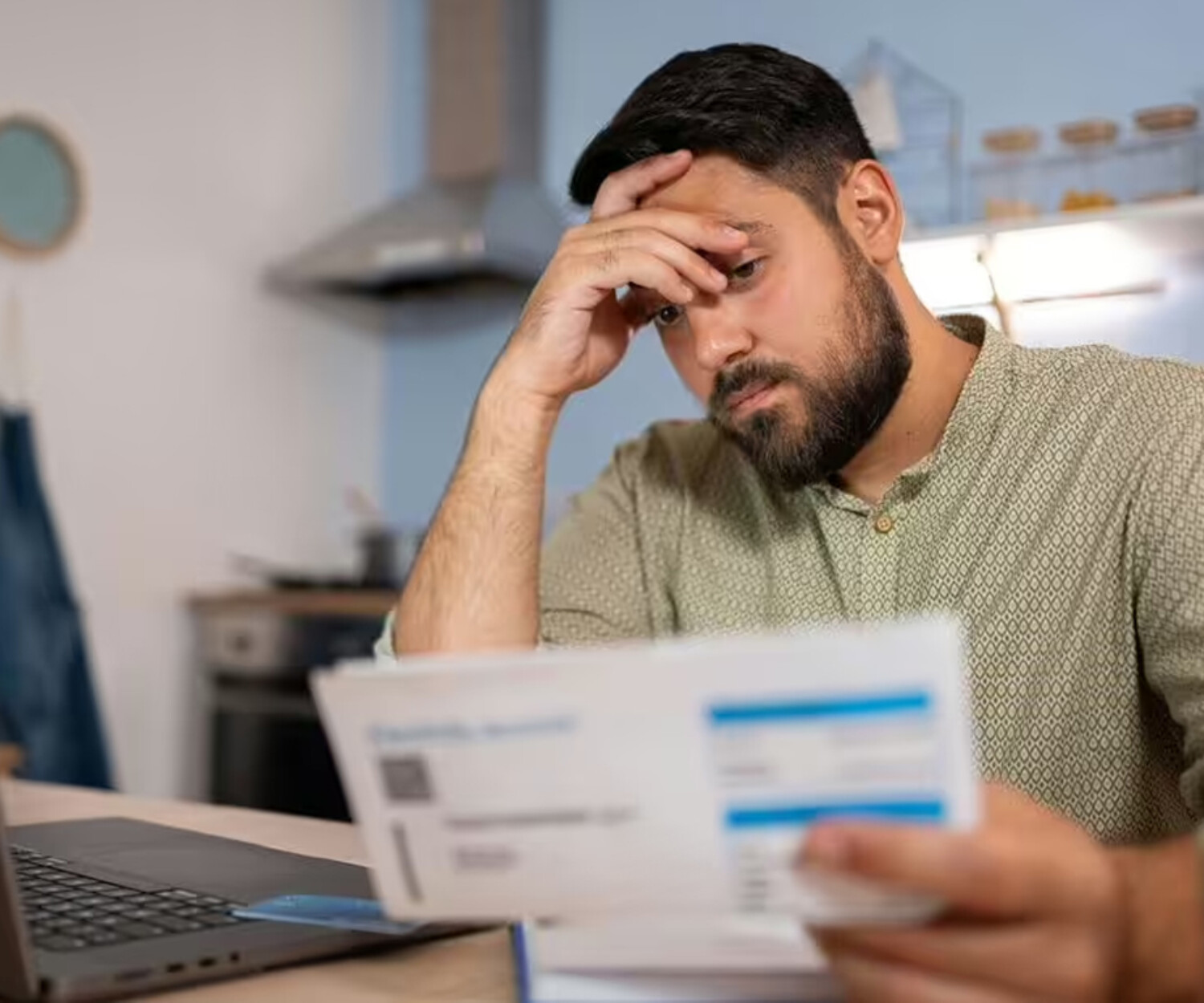A man looking at a report with his hand on his face in frustration